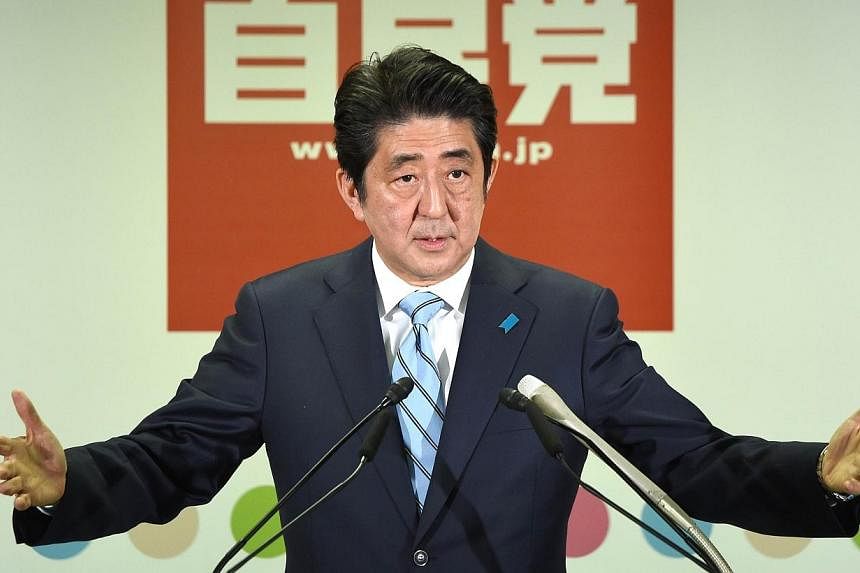 Japanese Prime Minister and President of the ruling Liberal Democratic Party (LDP) Shinzo Abe gestures as he answers questions during a press conference at the headquarters of the LDP in Tokyo on Dec 15, 2014. -- PHOTO: AFP