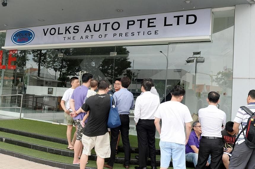 More than 20 people gathered outside a car dealership at MacPherson Road on Monday, after the dealership failed to deliver the cars they had bought. They wanted to look for the owner, whom they say have been uncontactable for a few days. -- ST PHOTO: