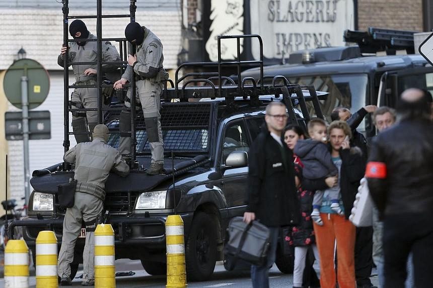 Belgian special forces handle a ladder near a building, where four gunmen have taken a man hostage, in Ghent on Dec 15, 2014.&nbsp;Three suspects in an armed hostage-taking incident in the Belgian city of Ghent surrendered to police Monday, reports s