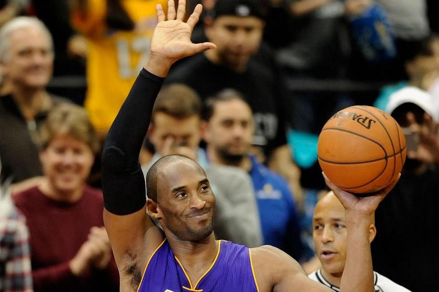 Kobe Bryant #24 of the Los Angeles Lakers waves to the crowd on Dec 14, 2014 at Target Center in Minneapolis, Minnesota. -- PHOTO: AFP