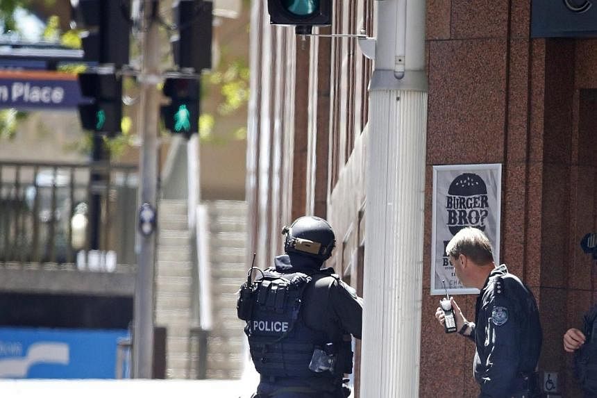 New South Wales state police officers are seen at a corner near Lindt cafe in Martin Place, where hostages are being held, in central Sydney on Dec 15, 2014. -- PHOTO: REUTERS