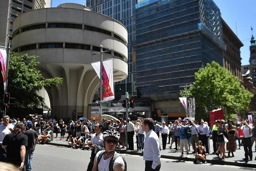 Onlookers gather in Martin Place in the central business district of Sydney on Dec 15, 2014.&nbsp;New South Wales police commissioner Andrew Scipione praised the Sydney public for its calm and cooperative reaction to the lockdown of part of the city'