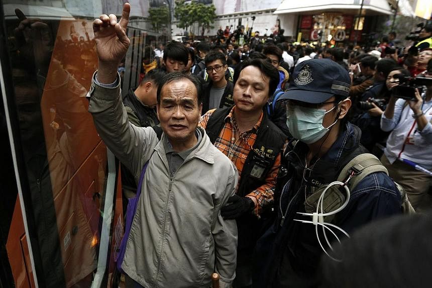 A pro-democracy protester chants slogans as he is taken away by the police during a clearance at the last protest site blocking a main road at Causeway Bay shopping district in Hong Kong on Dec 15, 2014. -- PHOTO: REUTERS