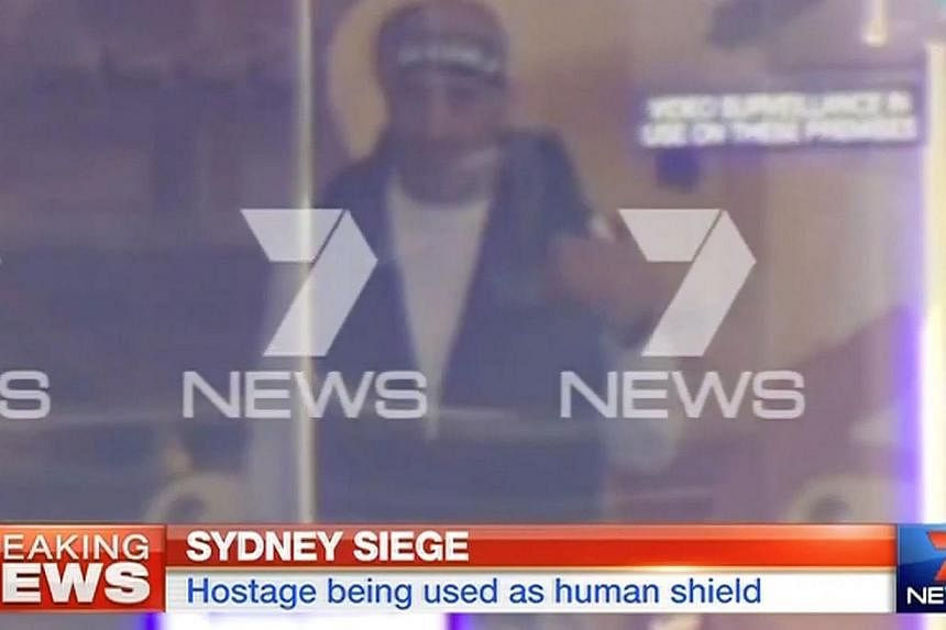 &nbsp;This screengrab taken from Australian Channel Seven shows the suspected gunman inside a cafe in the central business district of Sydney on Dec 15, 2014. -- PHOTO: AFP
