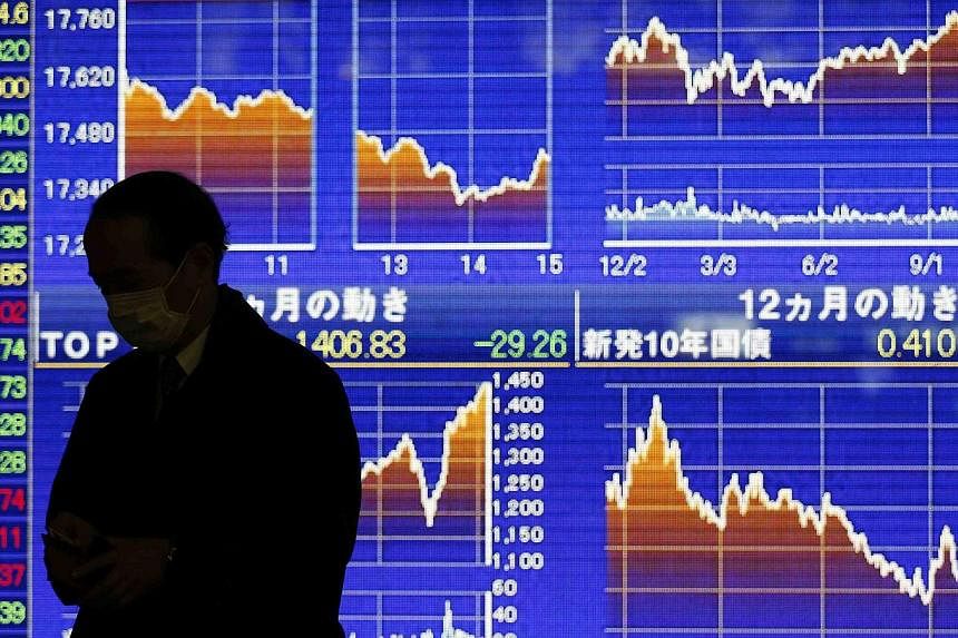 Japanese stocks fell on Monday after slumping oil prices toppled Wall Street shares, while investors drew little comfort from Prime Minister Shinzo Abe's landslide win in a snap election over the weekend. -- PHOTO: REUTERS