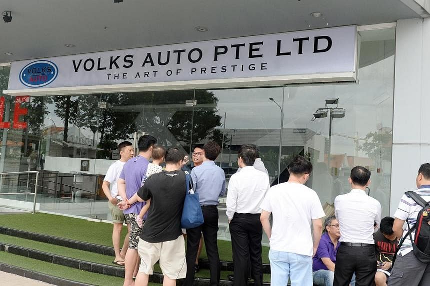 More than 20 people gathered outside Volks Auto, a car dealership in MacPherson Road, on Monday, Dec 15, 2014.&nbsp;Car buyers demanding refunds turned up for the second day in a row on Tuesday, as a WhatsApp chat group of car buyers claiming they ha