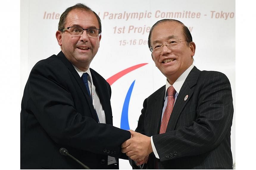 International Paralympic committee CEO Xavier Gonzalez (left) shakes hands with Tokyo Organising Committee of the Olympic and Paralympic Games CEO Toshiro Muto (right) in Tokyo on Dec 16, 2014.&nbsp;-- PHOTO: AFP