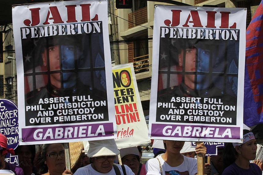 Activists display placards of US Marine Private First Class Joseph Scott Pemberton during a protest outside the presidential palace in Manila on Oct 28, 2014.&nbsp;The Philippine government sought formal custody on Dec 16, 2014, of the US marine char