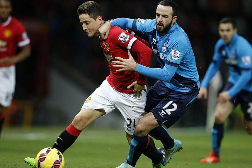 Manchester United's Ander Herrera (left) is challenged by Stoke City's Marc Wilson during their English Premier League football match at Old Trafford in Manchester, northern England on Dec 2, 2014. -- PHOTO: REUTERS