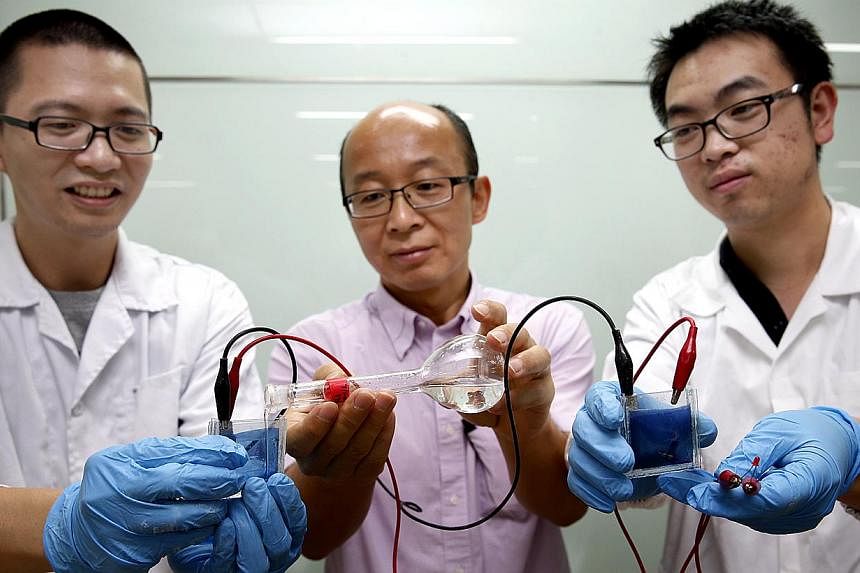 Nanyang Technological University (NTU) scientists (from left) Zheng Ke, Professor Sun Xiao Wei and Liu He have developed a smart window which can darken or brighten without the need for an external power source. -- ST PHOTO:&nbsp;LAU FOOK KONG