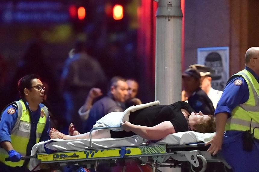 Paramedics remove a person on a stretcher from the Lindt cafe, where hostages were held at Martin Place in central Sydney early this morning. Australian security forces on Tuesday stormed the Sydney cafe ending a standoff that had dragged on for more