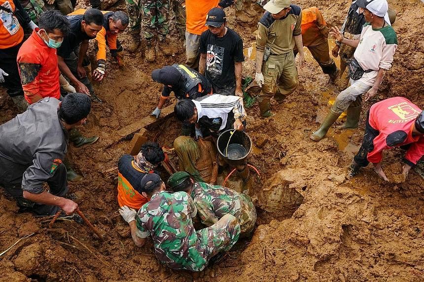 Members of a search and rescue team remove the body of a victim of a landslide at the Jemblung village in Banjarnegara in central Java on Sunday. PHOTO: AFP