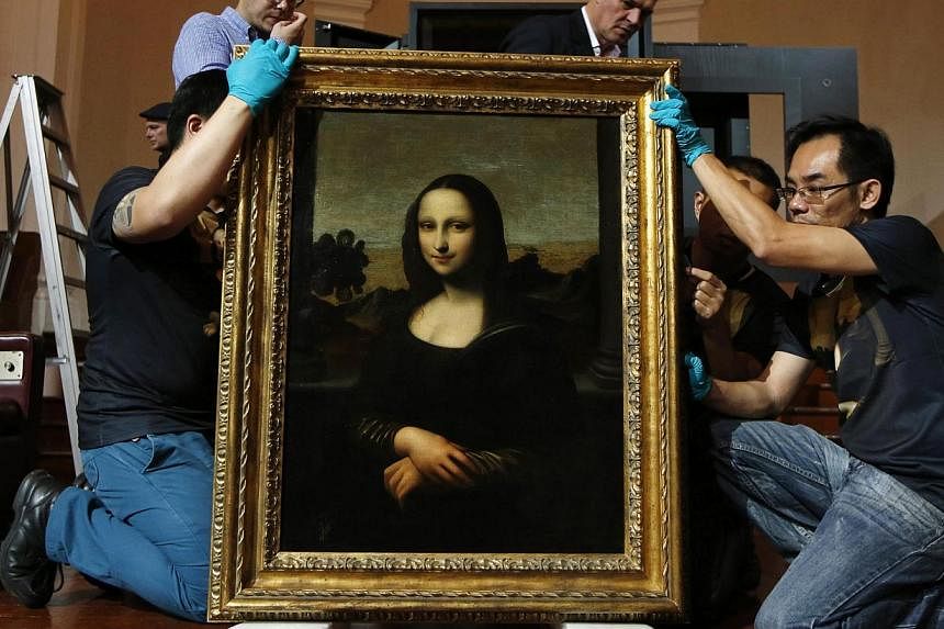 Movers prepare to hang Leonardo da Vinci's 'Early Mona Lisa' painting ahead of its exhibition at The Arts House in Singapore in this file picture taken last week. -- PHOTO: REUTERS
