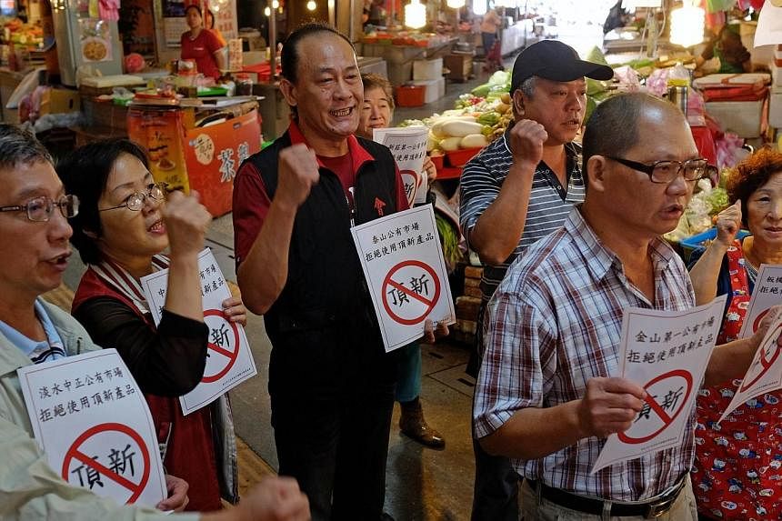 Local vendors from traditional markets display protest signs to boycott the Wei Chuan Foods Corp, which was caught up in a food scandal, in New Taipei City on Oct 14, 2014. In yet another food scandal in the territory, Taiwanese authorities have orde