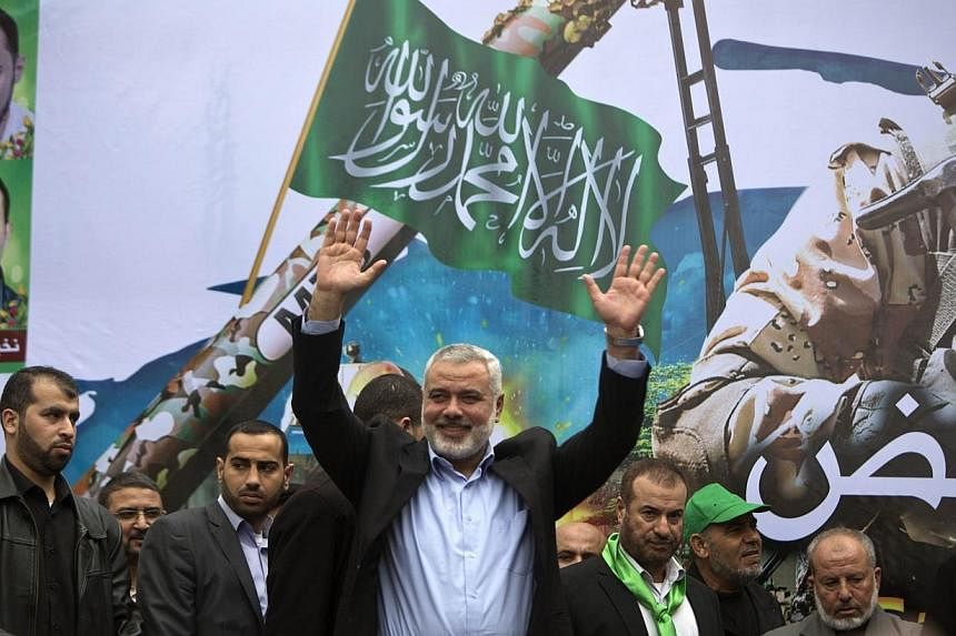 Gaza Hamas leader Ismail Haniya greets supporters during a rally to commemorate the 27th anniversary of the Islamist movement’s creation and to ask for the reconstruction of the Gaza Strip on Dec 12, 2014 in Jabalia refugee camp in the northern Gaz