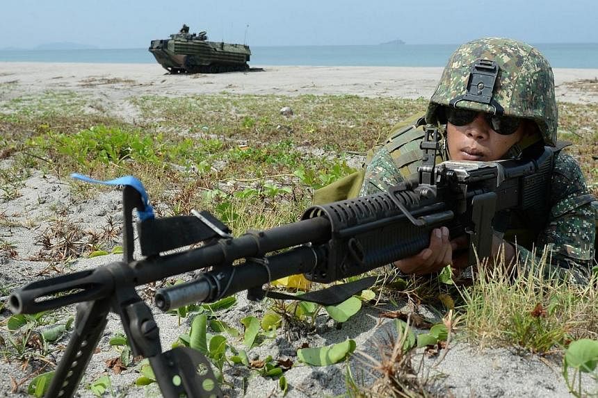 Philippine Marines take their positions next to an amphibious assault vehicle (AAV) of the US marines 31st Marine Expeditionary Unit based in Okinawa Japan, as part of the 12-day US and Philippine annual joint naval exercise dubbed "Phiblex" along th