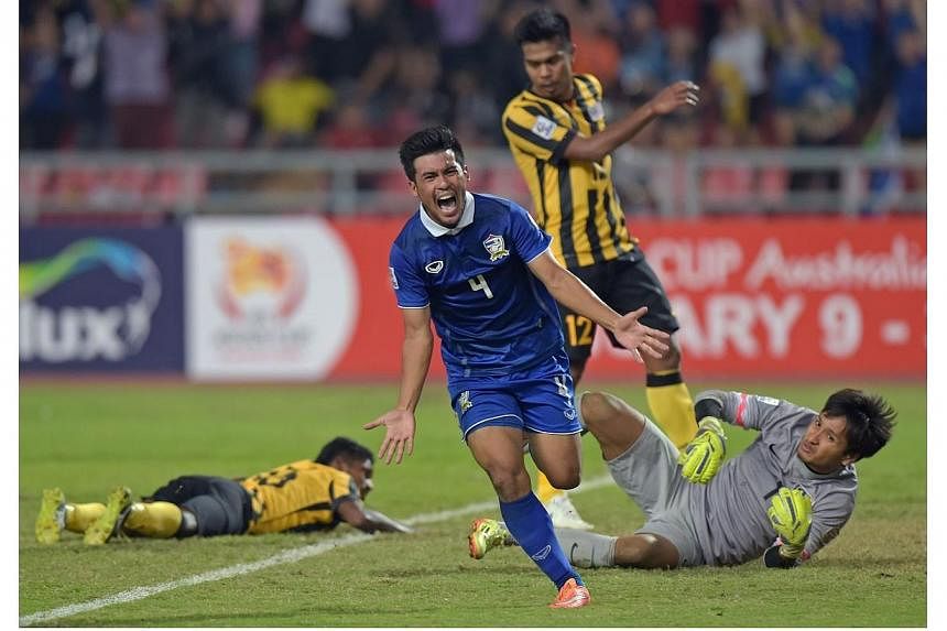Kroekrit Thawikan of Thailand (centre) celebrates after scoring against Malaysia during their final 1st leg football match of the Suzuki Cup 2014 at the Rajamangala stadium in Bangkok on Dec 17, 2014. Thailand won 2-0. -- PHOTO: AFP&nbsp;