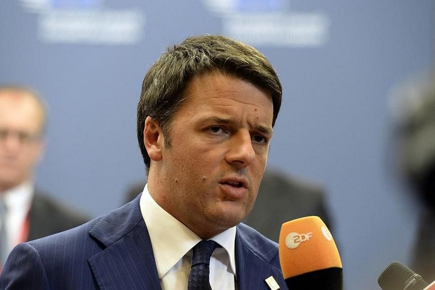 Italian Prime Minister Matteo Renzi talks to the media on Oct 24, 2014 at the end of a European summit at EU headquarters in Brussels. Mr Renzi has vowed to cut the towering debt pile of the eurozone's fifth-largest economy. -- PHOTO: AFP