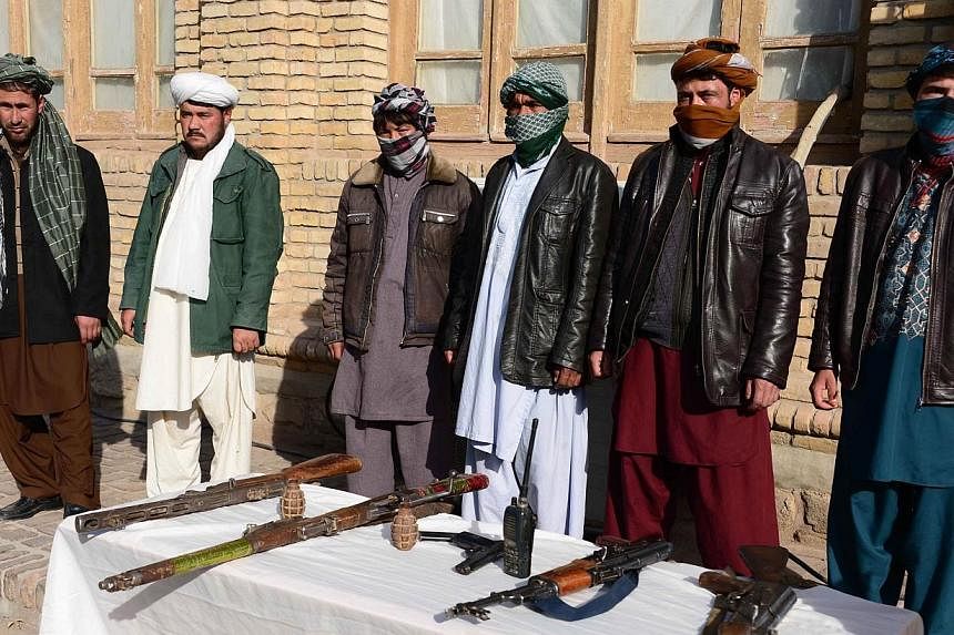 Former Taleban fighters stand with their weapons during a reconciliation process in Herat province on Nov 22, 2014. -- PHOTO: AFP