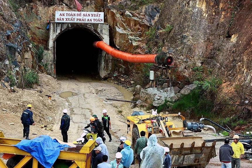 Workers and rescuers stand in front of the entrance of a tunnel at the Da Dang- Da Chomo hydroelectric power plant in Lac Duong district, central highland province of Lam Dong on Dec 16, 2014.&nbsp;Vietnamese rescuers battled on Wednesday, Dec 17, to