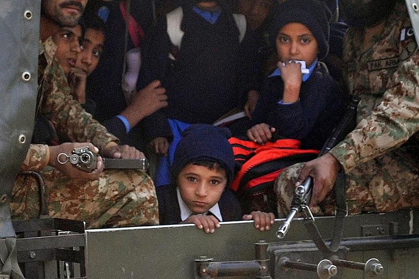 Pakistani soldiers transporting rescued school children from the site of an attack by Taleban gunmen on a school in Peshawar on Dec 16, 2014. -- PHOTO: AFP