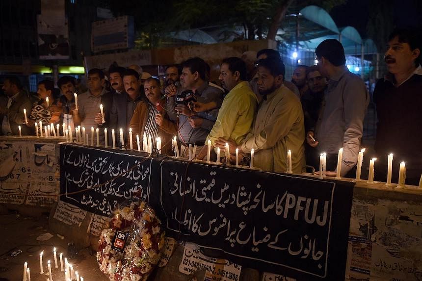 Pakistani journalists light candles for the victims of an attack by Taleban gunmen on a school in Peshawar, in Karachi on Dec 16, 2014. -- PHOTO: AFP