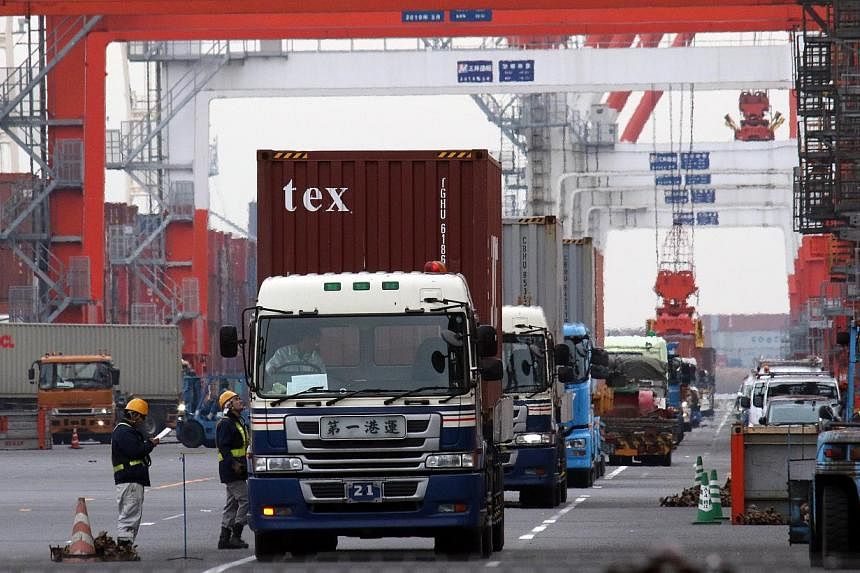 Containers are loaded onto trailer trucks at the port in Tokyo on Nov 20, 2014. Japan's exports grew for a third straight month in November from a year earlier, but much more slowly than expected and despite a sharp fall in the yen. -- PHOTO: AFP