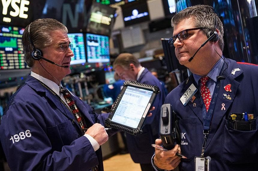Traders work on the floor of the New York Stock Exchange on Dec 17, 2014. Economists at Wall Street's biggest banks remain convinced the Federal Reserve will raise interest rates by next June and most expect the Fed to tighten policy more than once i
