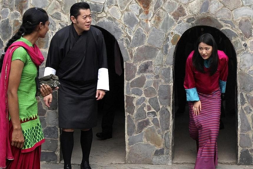 Bhutan's King Jigme Khesar Namgyel Wangchuck (2nd from left) and Queen Jetsun Pema (right) emerge from arch-shaped passages as they visit the Rock Garden in the northern Indian city of Chandigarh Oct 5, 2014.&nbsp;The king of Bhutan on Thursday urged