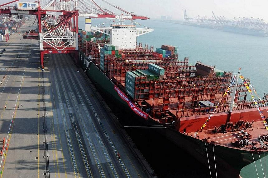 The CSCL Globe at Qingdao port on Dec 4, 2014. The world's largest vessel by container volume made its maiden call on Singapore on Thursday. -- PHOTO: AFP