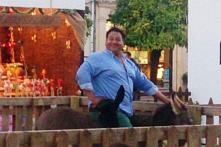 A photo widely circulating on social media show the portly man, who wore a blue shirt and green pants, grinning as he poses on the donkey. -- PHOTO: PODEMOS ANIMALISTA LUCENA/ FACEBOOK