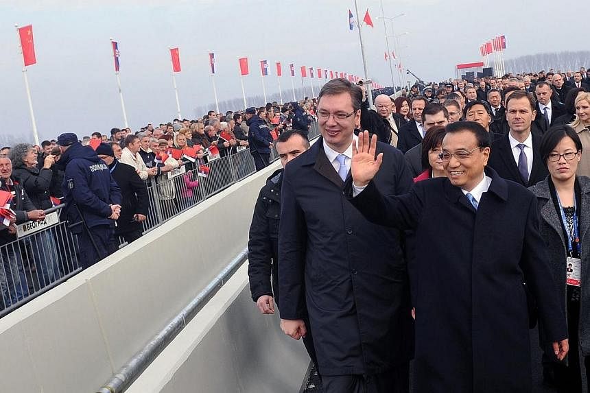 Chinese Prime Minister Li Keqiang (right) waves next to Serbian counterpart Aleksandar Vucic (left) during the opening ceremony of Europe's first Chinese-built project near Belgrade on Dec 18, 2014.&nbsp;The Chinese and Serbian prime ministers inaugu