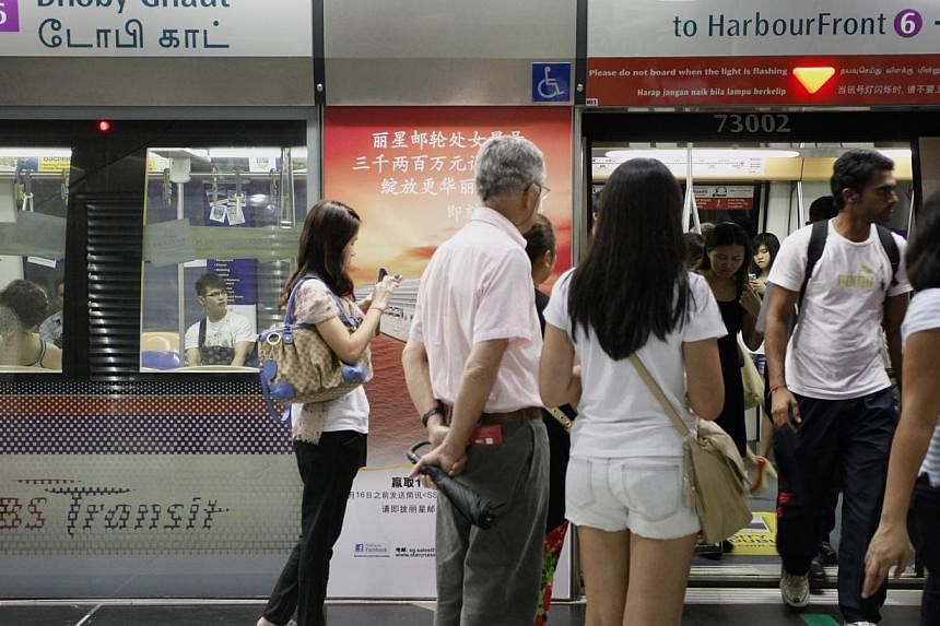 People waiting to enter the train at Dhoby Ghaut MRT station along the North-East line during peak hour. By the end of next year, all MRT stations on the North-East Line and 12 more stations on the North-South Line and East-West Line will offer free 