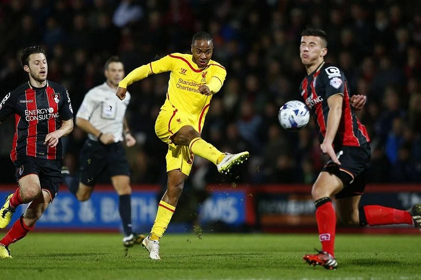 Raheem Sterling of Liverpool shoots past Baily Cargill of Bournemouth during their English League Cup quarter-final soccer match at Goldsands Stadium in Bournemouth, southwest England on Dec 17, 2014.