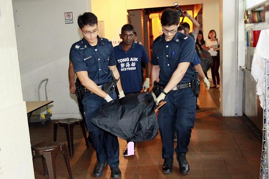 Police taking away the victim's body from the flat early yesterday morning.