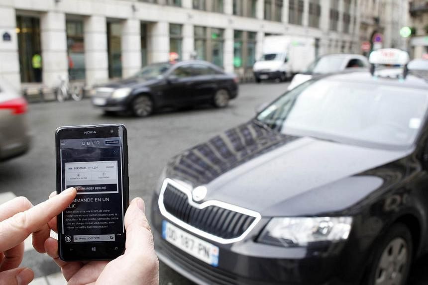 The Uber smartphone app being used used to book a &nbsp;taxi in Paris on Dec 10, 2014. Uber, which had a driver was accused of rape in New Delhi, said it was exploring adding new methods to verify drivers'credentials and make its service safer.