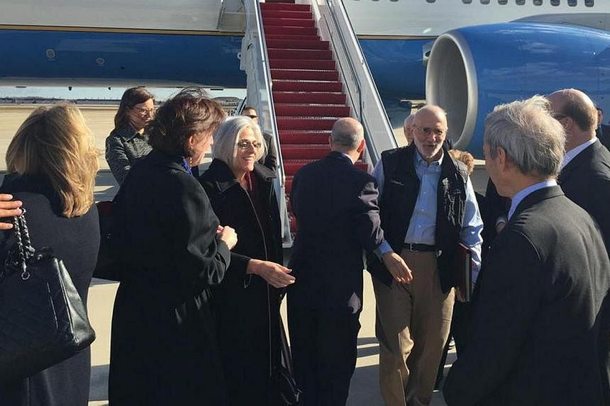 American aid worker Alan Gross (third right) disembarks with his wife Judy (fourth left) from a US government plane as he arrives at Joint Base Andrews, Maryland outside Washington Dec 17, 2014 in this photo tweeted by US Senator Jeff Flake. -- PHOTO