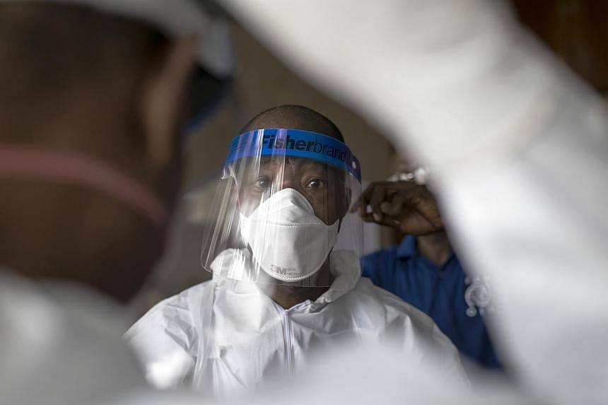 Sierra Leonean doctors practise wearing protective clothing in the Ebola Training Academy in Freetown, Sierra Leone, Dec 16, 2014. The death toll in the Ebola epidemic has risen to 6,915 out of 18,603 cases as of Dec 14, the World Health Organisation