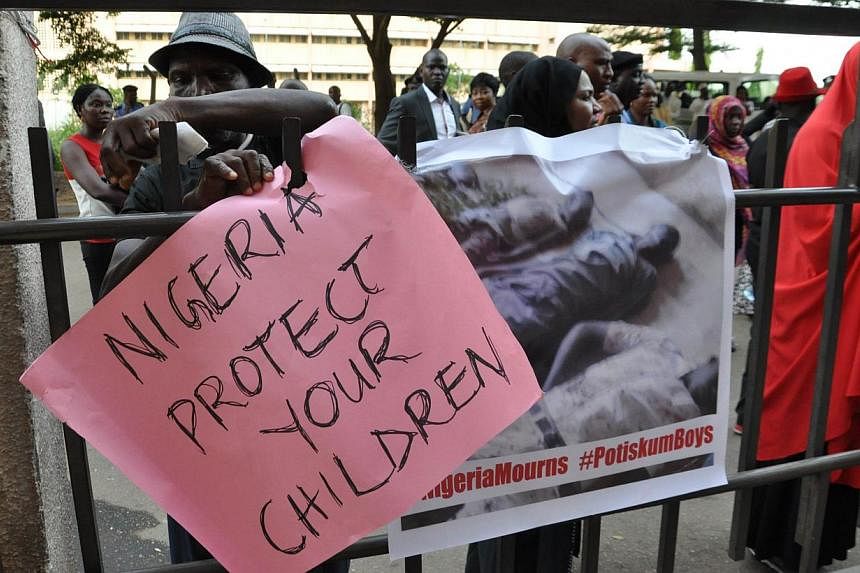A civil society group carrying posters march on Nov 17, 2014 to protest the killing of over 47 students of Portiskum Government Comprehensive School in Yobe State, during an Assembly ground on Nov 10, 2014. -- PHOTO: AFP