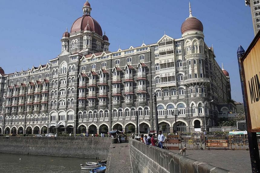 Tourists sit in front of the Taj Mahal hotel, which was one of the targets of the Nov 26, 2008 attacks, in Mumbai on Nov 26, 2014. -- PHOTO: REUTERS