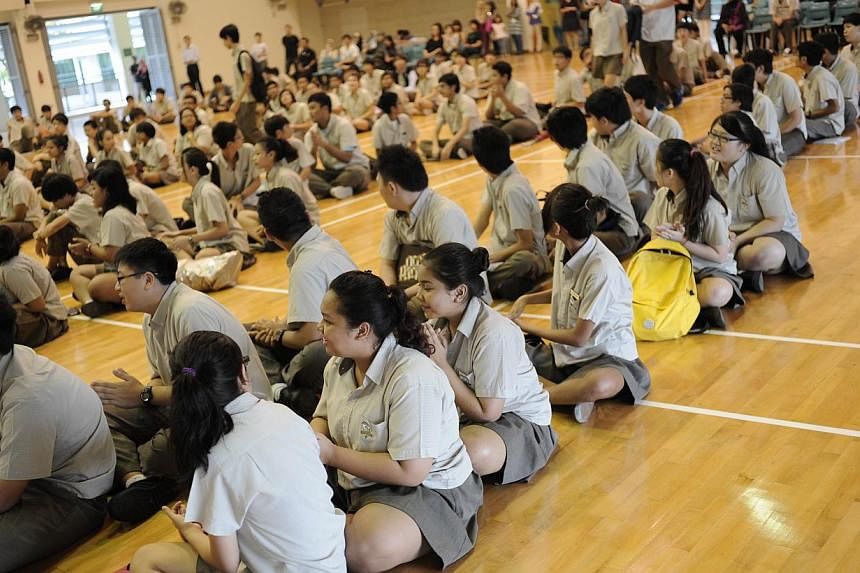 Students at Bedok Green Secondary School waiting to get the results for their N-level examinations on Dec, 17 2012. More students did well enough at the N-levels this year to make the cut for Secondary 5. -- PHOTO: ST FILE