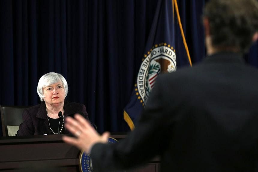 A reporter asks a question during a news conference held by US Federal Reserve cchairman Janet Yellen (left) at the Federal Reserve in Washington Dec 17, 2014. -- PHOTO: REUTERS