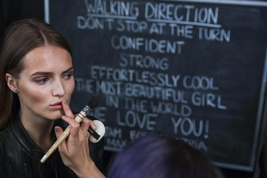A model having make-up applied backstage before showing the BCBG Max Azria collection during New York Fashion Week on Sept 4, 2014. The fashion extravaganza was accused of misusing Damrosch Park, adjacent to Lincoln Center. -- PHOTO: REUTERS