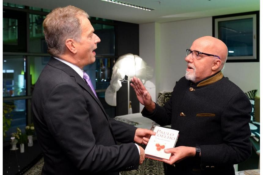 Finland's President Sauli Niinisto (left) speaking with Brazilian writer Paulo Coelho on Oct 7, 2014, during the opening of the Frankfurt Book fair. Coelho offered on Thursday to pay Sony US$100,000 (S$131,400) for rights to North Korean parody film 