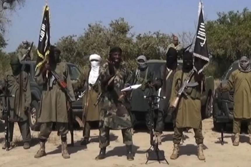 An image grab on October 31, 2014 from a video obtained by AFP shows the leader of the Islamist extremist group Boko Haram Abubakar Shekau (centre) delivering a speech. --PHOTO: AFP&nbsp;