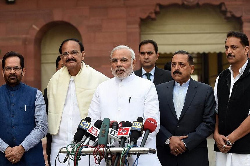 Indian Prime Minister Narendra Modi (centre) addresses the media as Minister of State for Parliamentary Affairs Mukhtar Abbas Naqvi (left), Urban Development Minister Vankaiah Naidu (second, left), Minister of State (PMO) Jitender Singh (second, righ