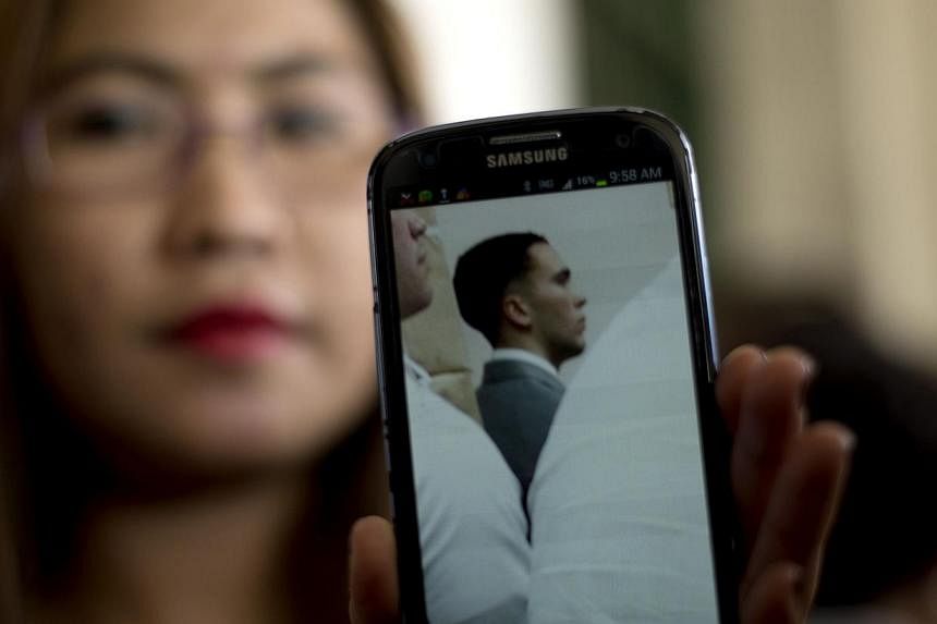 Marilou Laude, sister of Jeffrey Laude, 26, shows a picture of Private First Class Joseph Pemberton, from her phone inside a Philippine court in Olongapo City, north of Manila on Dec 19, 2014. -- PHOTO: AFP