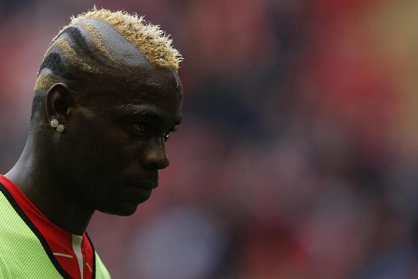 Liverpool striker Mario Balotelli (above) has been suspended for one match, fined £25,000 (S$51,000) and ordered to attend to an education course after making racist and anti-semitic comments. -- PHOTO: REUTERS
