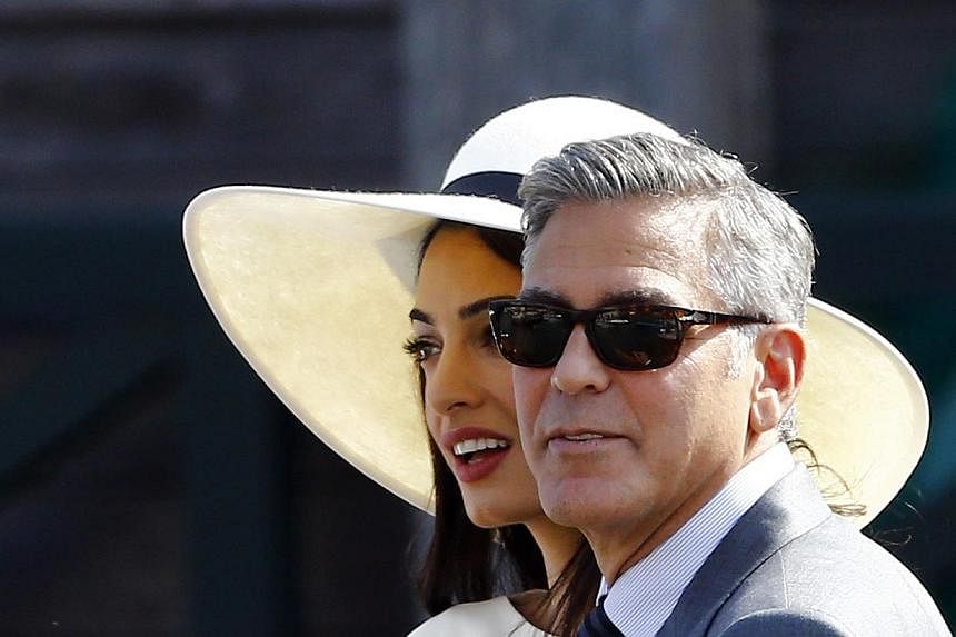 George Clooney (right) and his wife Amal Alamuddin leave Venice city hall after a civil ceremony to formalise their wedding in Venice, Italy on Sept 29, 2014. Clooney has stood up to criticise Hollywood for not rallying behind Sony Pictures as it was