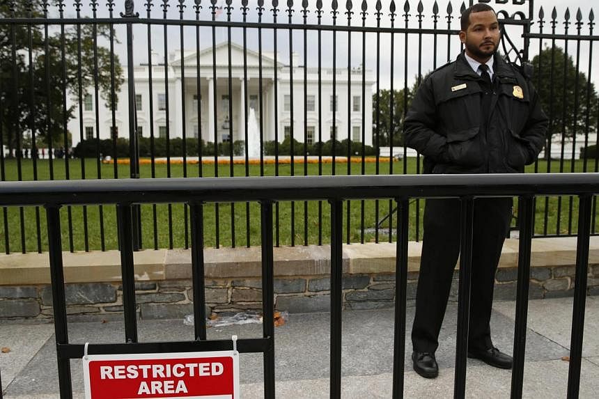 A member of the US Secret Service stands guard in front of the North Lawn of the White House in Washington Oct 23, 2014.&nbsp;&nbsp;The White House fence should be immediately raised by four or five feet (1.2m to 1.5m), according to an independent se